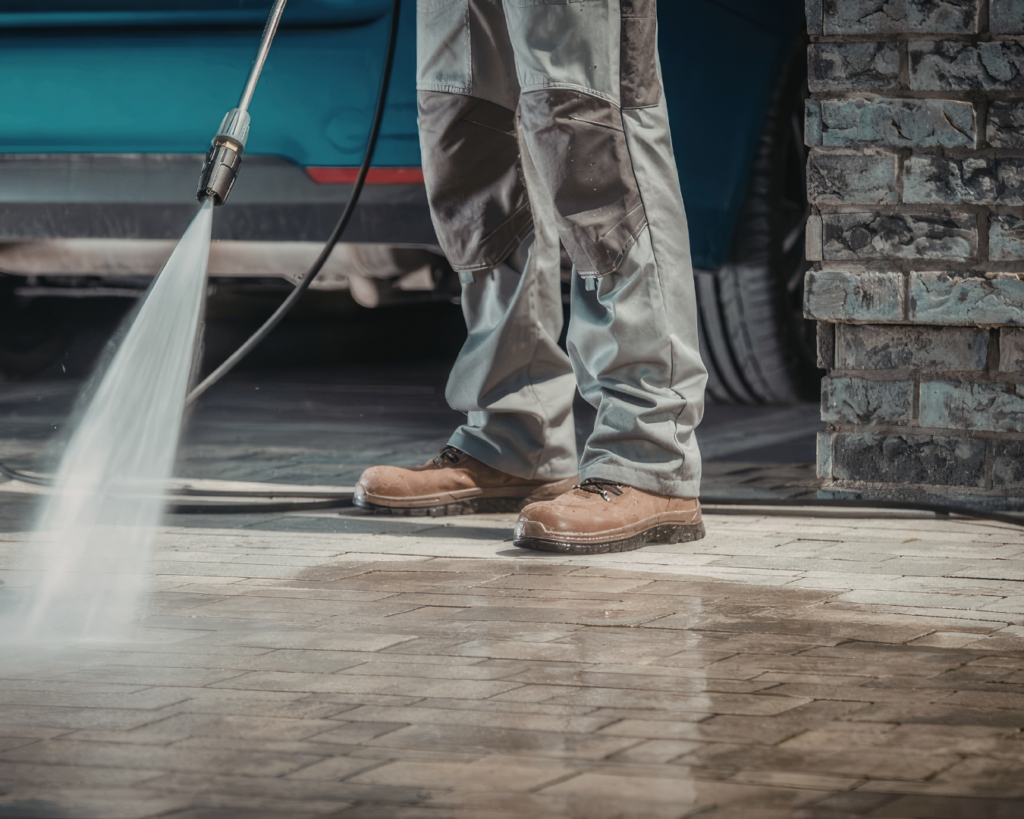 Man pressure washing a driveway