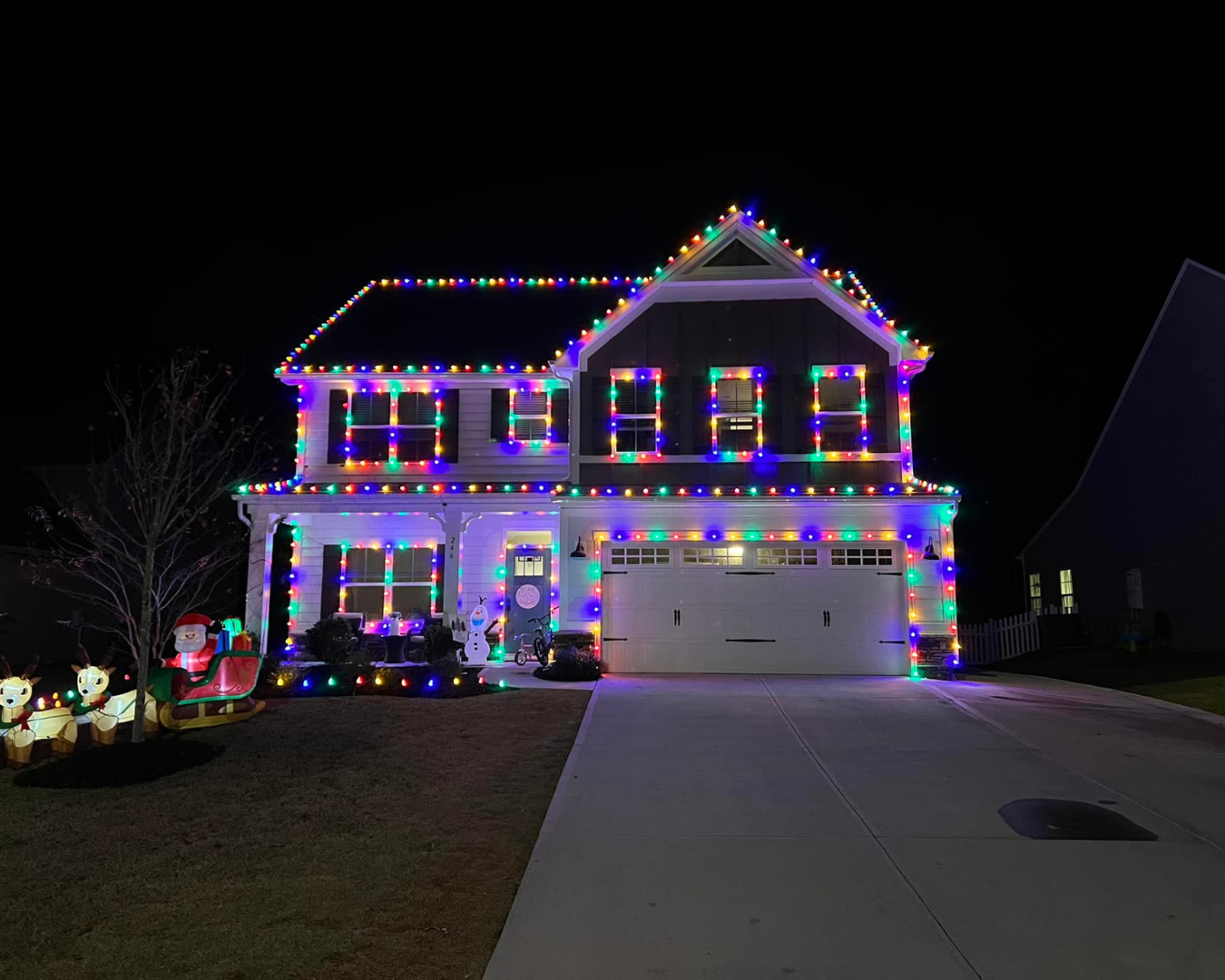 Beautiful, two-story home, neatly lined with multicolor Christmas lights.