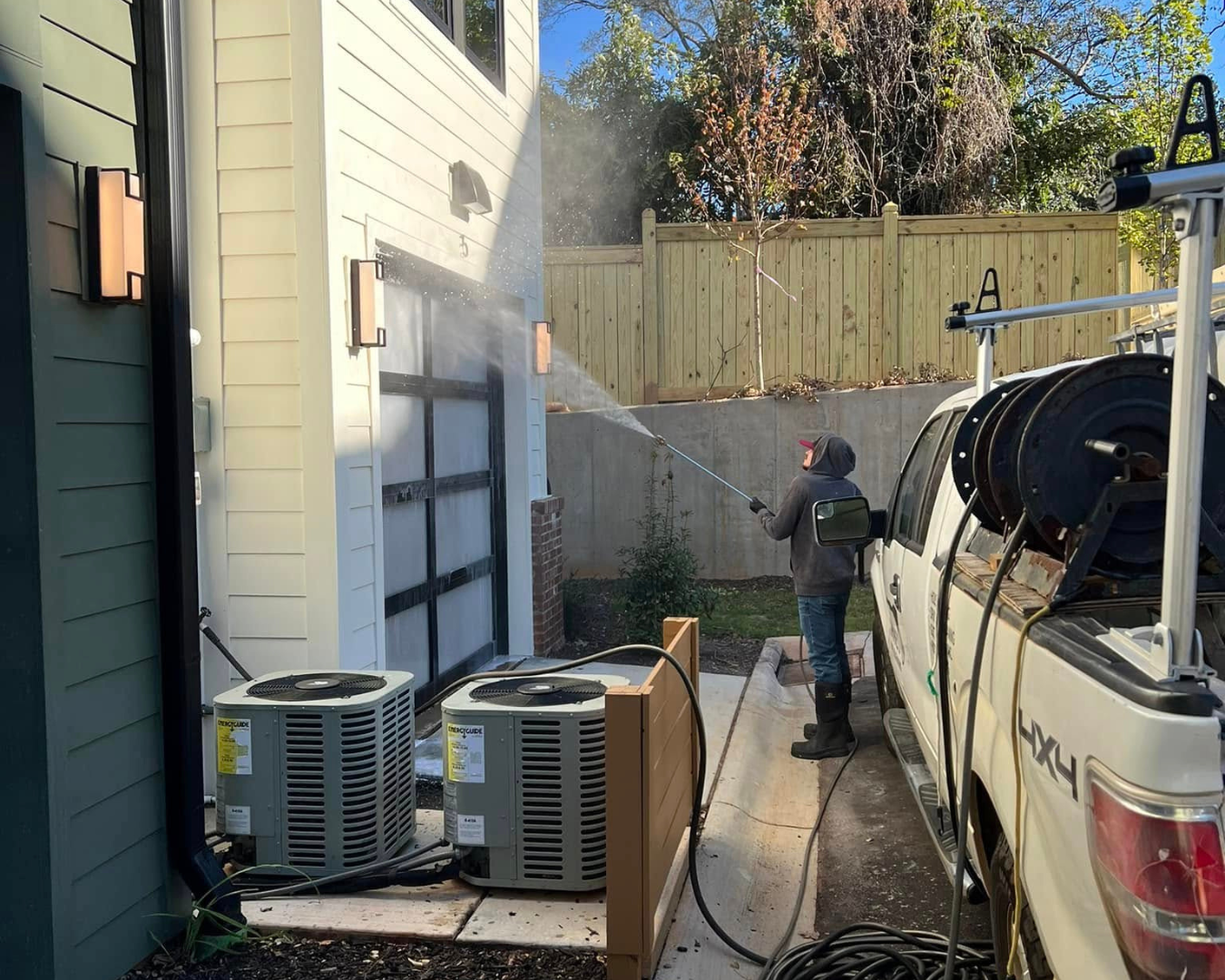 Shane's Power House Washing team member, pressure washing siding on home.