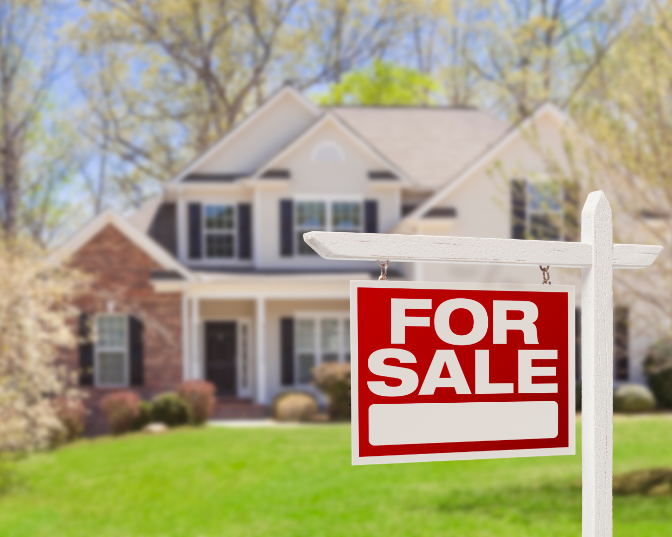 Beautiful two story residential home with a large red "for sale" sign out front.